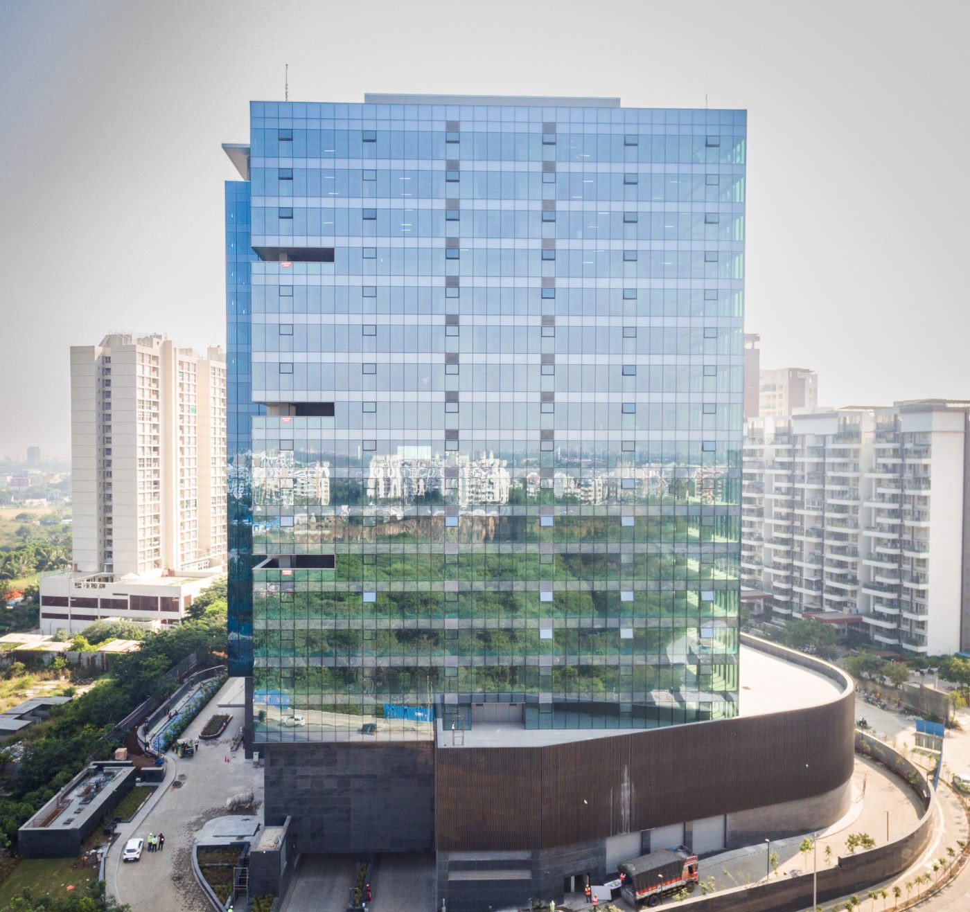 Commercial building facade drone inspection Pune — angled aerial view showing building context and all elevations, AerialPhotoIndia