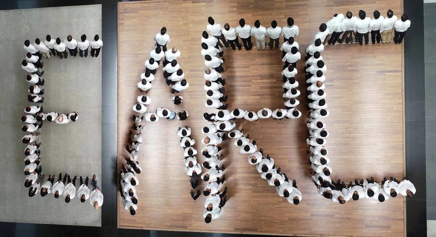 Corporate aerial photography drone top-down view — people forming letters, creative concept shot by AerialPhotoIndia Pune