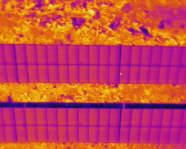 Close-range drone thermal inspection showing hotspot bands — soiling faults detected by thermal imaging, AerialPhotoIndia